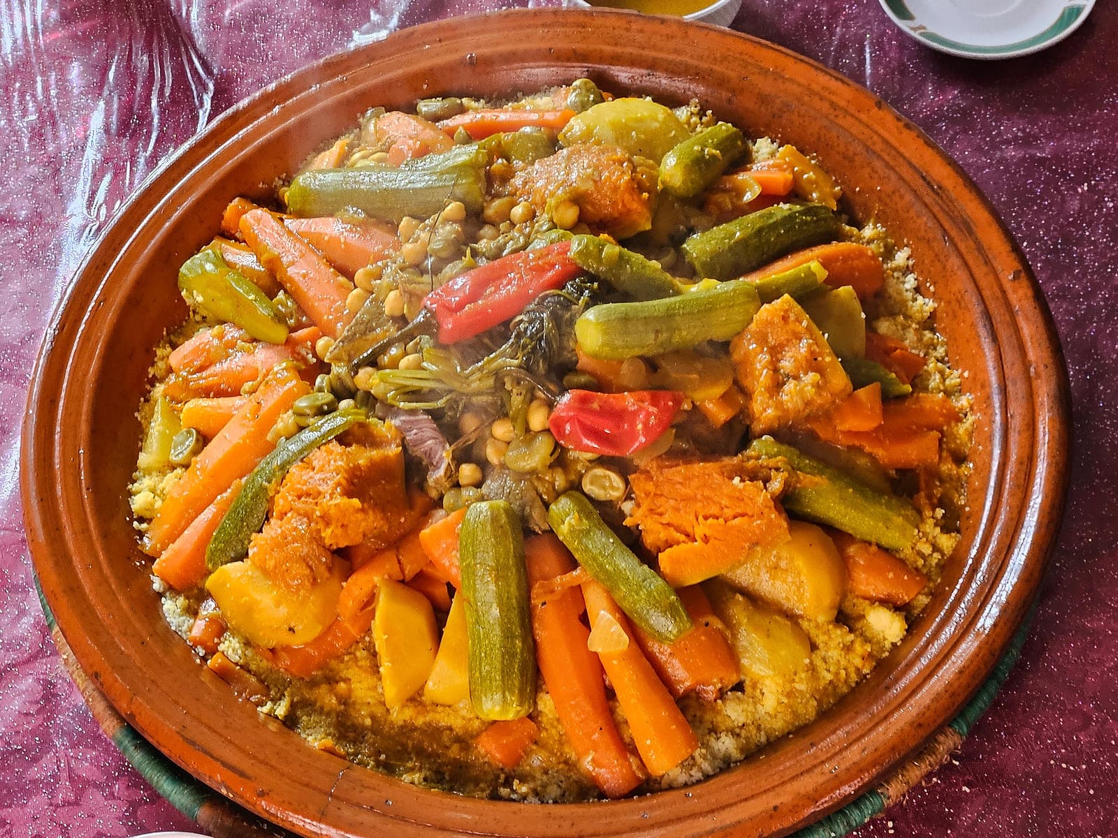 Platter of Moroccan couscous topped with carrots, turnips, pumpkin, courgette and chickpeas