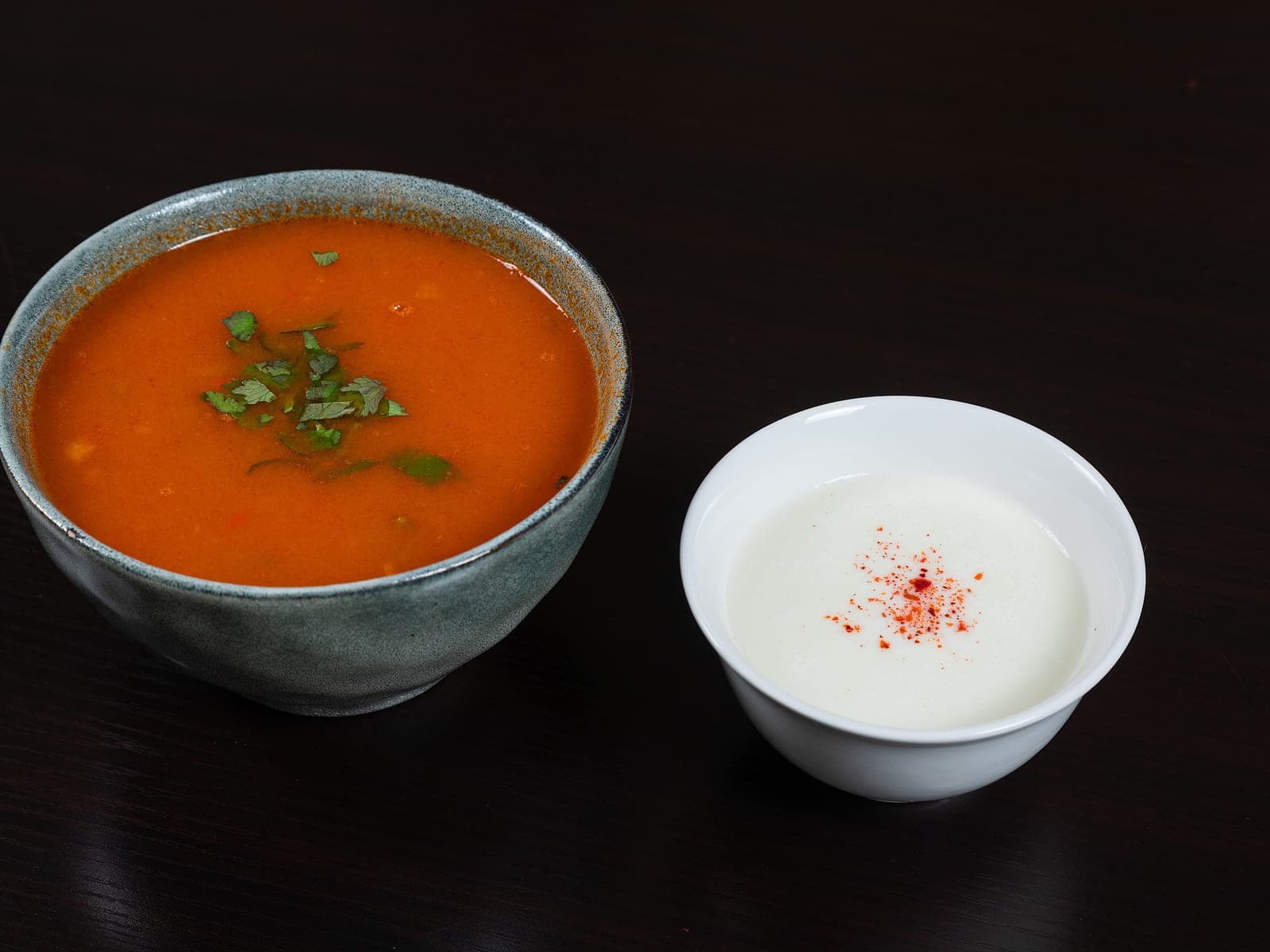 Bowl of thick Moroccan lentil soup topped with olive oil, cumin and chopped coriander